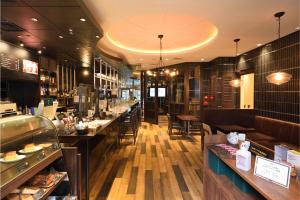 a restaurant with tables and chairs and a counter at Hakata Green Hotel Tenjin in Fukuoka