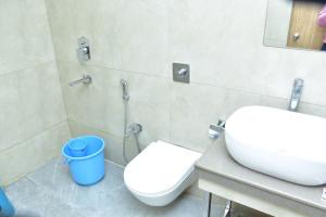 a bathroom with a white toilet and a sink at Hotel safal exotica in Puri +17 photos