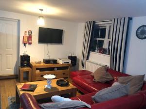 a living room with a red couch and a table at Waterside annexx in Durham