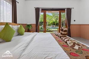 a bedroom with a bed and a view of a pool at The Bingin Green View by Bukit Vista in Uluwatu