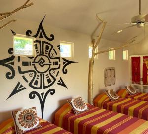two beds in a room with a mandala on the wall at Villa de Dos Armadillos in Santa Maria Huatulco +41 photos