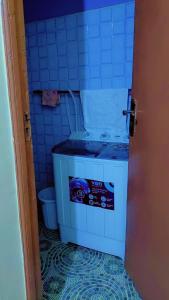 a blue tiled bathroom with a toilet in a room at LJ Homes in Kisii
