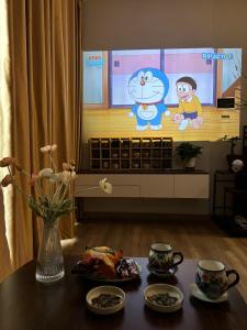 a room with a table with a tv with a cat on it at Măng Homestay in Xuân Quan