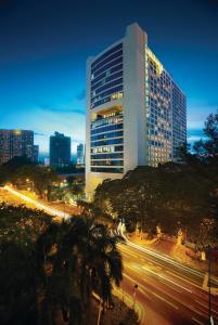 Hotel Maya Kuala Lumpur City Centre في كوالالمبور: مبنى طويل مع إضاءة في مدينة في الليل