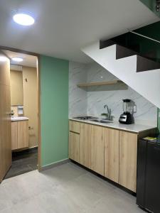a kitchen with a sink and a staircase at Amaranto Suites in Medellín +8 photos