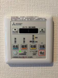 a remote control on a wall with writing on it at Jintai House202 in Shiobaru