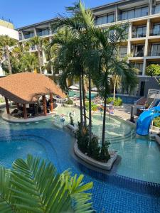 a swimming pool with palm trees and a hotel at Wyndham studio 2205 in Surin Beach