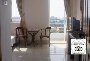 a room with a tv and chairs and a window at Kiet Hong Hotel in Rạch Giá