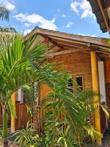 a wooden house with palm trees in front of it at Beach cabin uppuveli in Trincomalee
