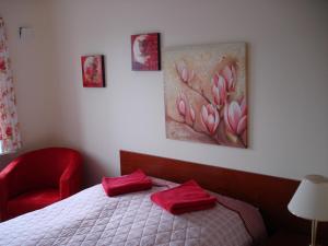 Un dormitorio con una cama con almohadas rojas y una pintura en Strandidyl Bed & Breakfast, en Kelstrup