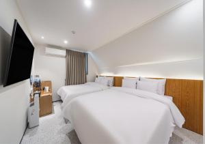 a hotel room with two beds and a flat screen tv at Incheon Juan Chungchoon Hotel in Incheon