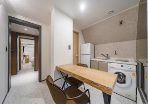 a kitchen with a table and a washer and dryer at Incheon Juan Chungchoon Hotel in Incheon