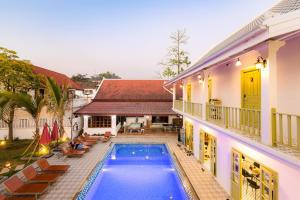 a house with a swimming pool next to a building at White Elephant Hostel in Luang Prabang