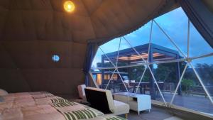a bedroom with a bed and a large window at glampark Sesoko -Ocean Terrace- in Sesoko