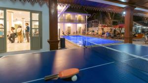 a ping pong table in front of a swimming pool at White Elephant Hostel in Luang Prabang