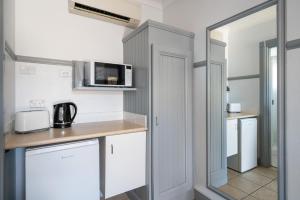 a kitchen with white cabinets and a microwave at Ben Chifley Motor Inn in Bathurst