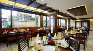 a restaurant with tables and chairs in a restaurant at Hotel safal exotica in Puri
