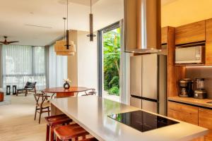 a kitchen with a counter and a dining room at Bloom Tulum, Apartments by Marriott Bonvoy in Tulum