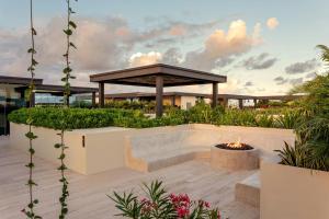 a courtyard with a fire pit and a gazebo at Bloom Tulum, Apartments by Marriott Bonvoy in Tulum