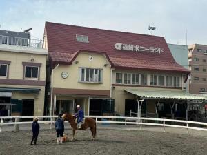 a person riding a horse in front of a building at 板東ビル in Tokyo