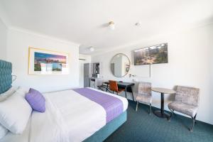 a hotel room with a bed and a table and chairs at Ben Chifley Motor Inn in Bathurst +17 photos