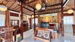 a living room with wooden ceilings and a dining room at Alamanda Villas, Family Villas, Pool & Local Tours in Yogyakarta