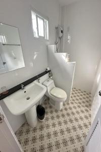 a white bathroom with a sink and a toilet at Be Leaf Resort SHA in Thalang +29 photos