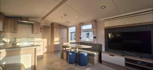 a kitchen and living room with a large flat screen tv at Mason's Morecambe Memories in Heysham