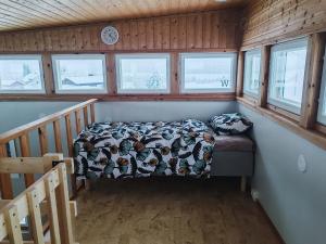 a bedroom with a bed in a room with windows at Lumikko Aurora Loft in Enontekiö