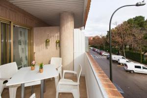 a balcony with white tables and chairs and a street at El rincón de las Delicias in Zaragoza