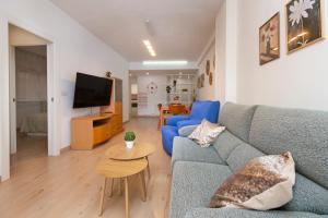 a living room with a blue couch and a table at El rincón de las Delicias in Zaragoza