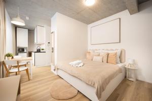 a white bedroom with a bed and a kitchen at Internesto Brno HUB in Brno