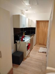 a kitchen with white cabinets and a stove top oven at Appartement Neuf Raismes in Raismes