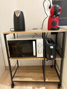 a microwave on a table with a blender on it at Appartement Neuf Raismes in Raismes