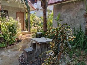 a picnic table in a garden next to a house at กานต์รีสอร์ต เชียงดาว in Ban Thung Kala