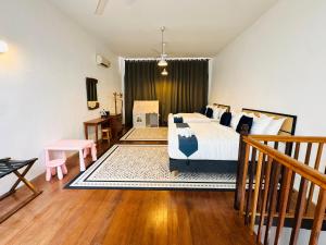 a bedroom with a bed and a wooden floor at Courtyard by Heritage Row in George Town