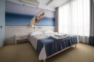 a bedroom with a bed and a table and a window at Hotel Morski Gdynia in Gdynia