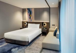 a hotel room with a bed and a chair at Hyatt Place Busan Yeonsan in Busan +26 photos