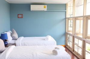 a room with two beds and a blue wall at Baan Ongkharak bed & breakfast in Bangkok +5 photos