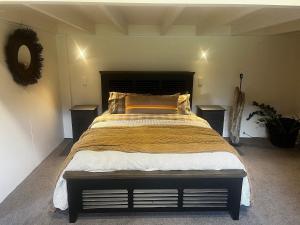 a large bed in a room with two tables at Barn Apartment in Earnscleugh