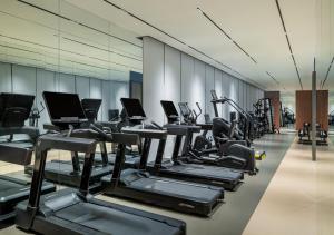a gym with a row of treadms and cardio machines at Hyatt Place Busan Yeonsan in Busan