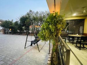 a patio with chairs and trees and a table at Hotel Royal Swiss in Sauraha