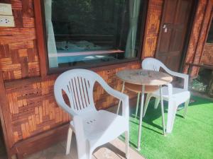 two chairs and a table on the porch of a cabin at saithai forest homstay in Krabi