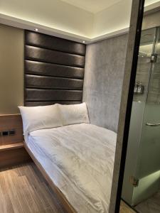 a bedroom with a bed with a black headboard at M Plus Hotel in Hong Kong +2 photos
