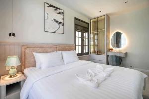 a bedroom with a white bed with a flower on it at Golden Terra Villa in Phan Thiet +17 photos