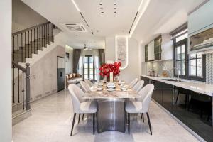 a dining room with a table and white chairs at Golden Terra Villa in Phan Thiet