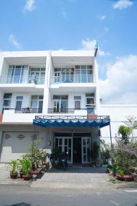 a white building with a blue awning on it at Tâm An Hotel in Nhơn Trạch