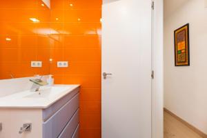 an orange bathroom with a sink and a mirror at El rincón de las Delicias in Zaragoza +35 photos