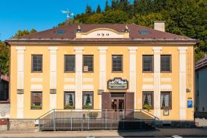 a large yellow building with a brown roof at Formanka Hanušovice in Hanušovice