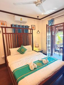 two stuffed animals sitting on a bed in a room at Villa Xiengthong Garden View Hotel in Luang Prabang